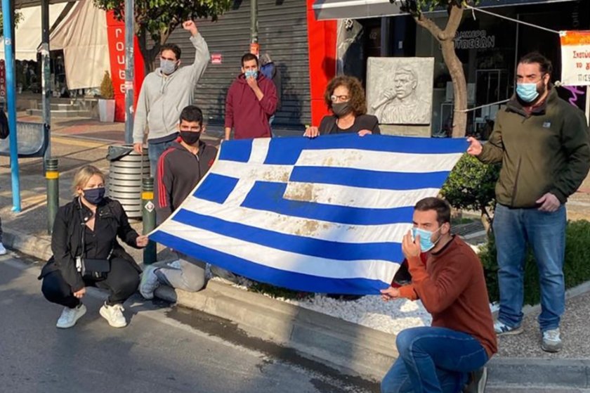 Η Μάγδα Φύσσα στο μνημείο του Παύλου με την αιματοβαμμένη σημαία του Πολυτεχνείου